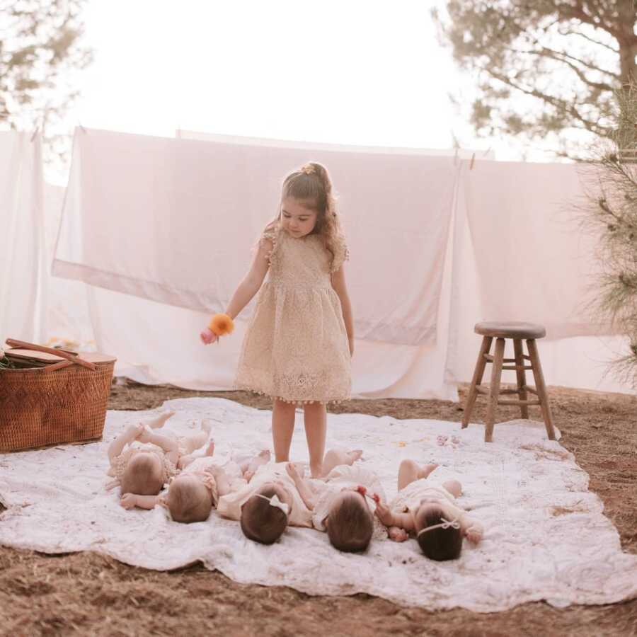 Big sister offers flowers to her quintuplet sisters