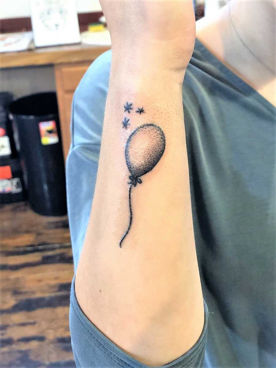 tattoo of a balloon in a woman's forearm 