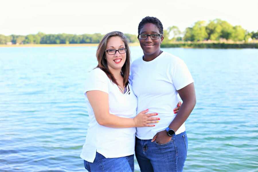 portrait of lesbian transracial couple in front of a lake