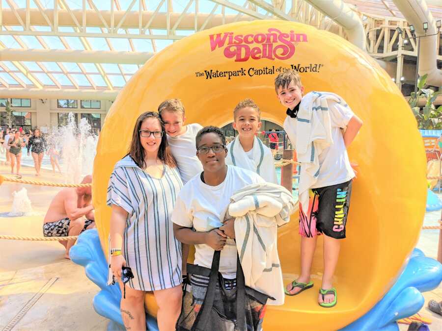 LGBT moms and their sons in a water park standing next to a giant, round lifebuoy