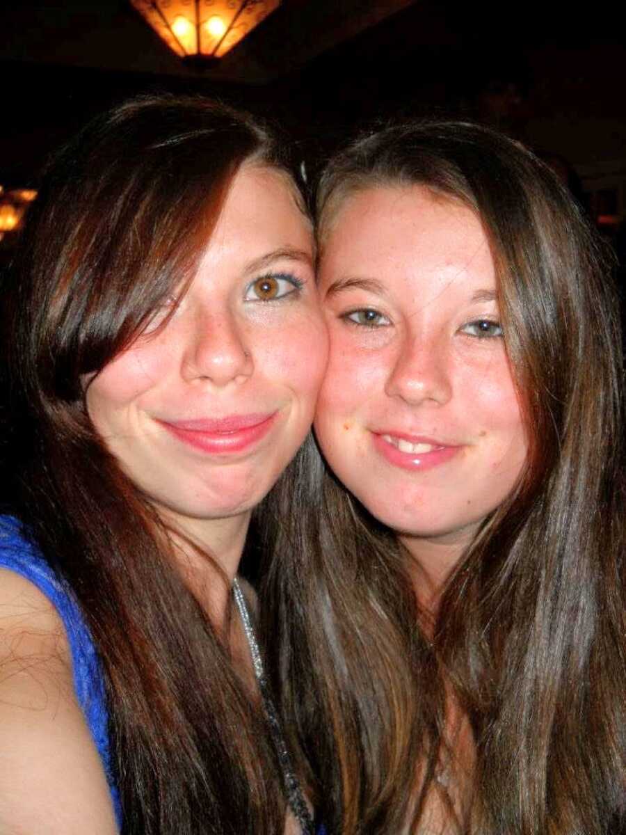 Sisters with the same dark brown hair take an up-close selfie together