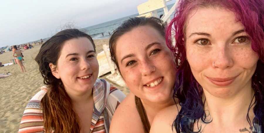 Older sister takes a selfie with her twin sisters while they enjoy a day at the beach together