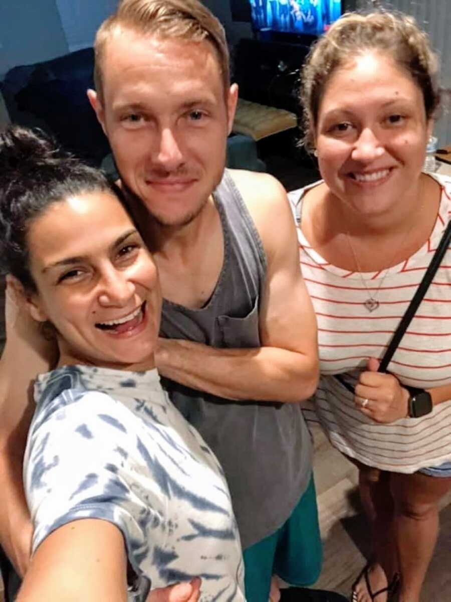 Adoptive woman takes a selfie with her two biological siblings