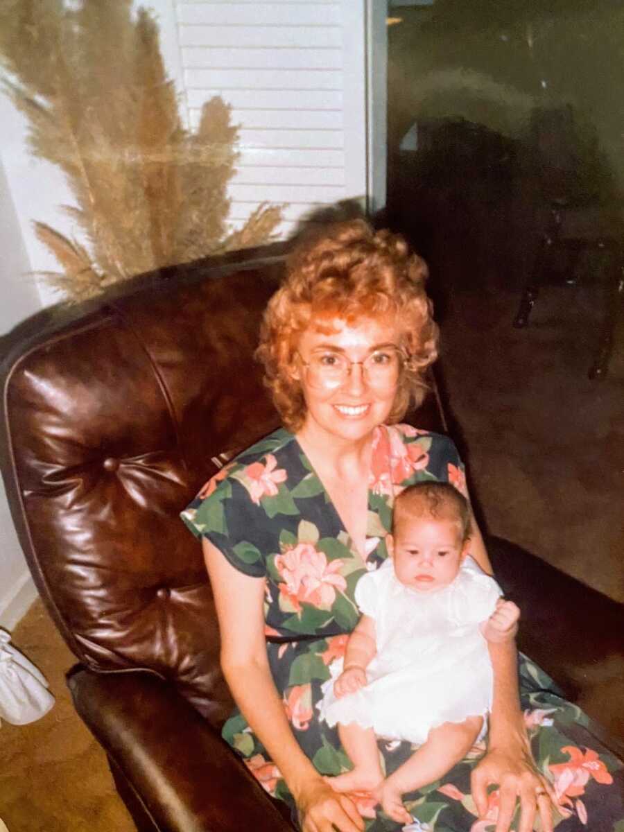 Adoptive mom holds newborn adoptive daughter in a recliner