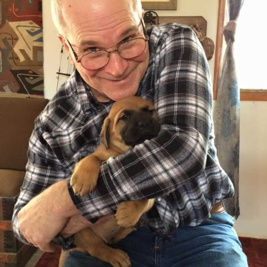 father holding new puppt smiling