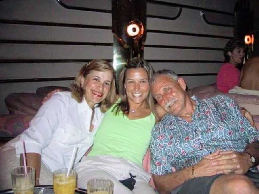 Daughter sits between her parents while enjoying dinner together on vacation