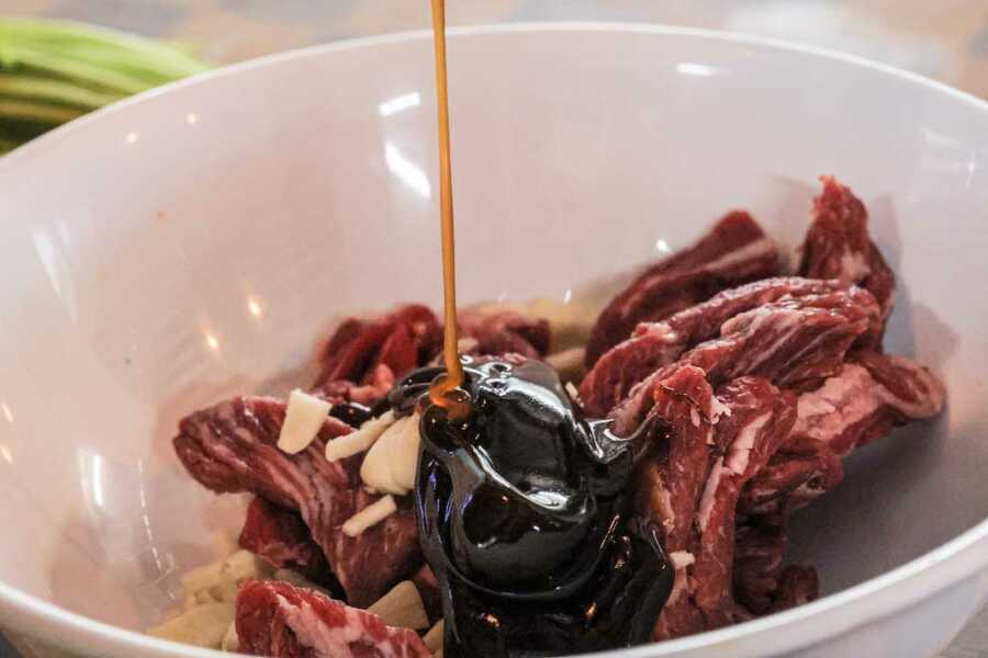 marinating beef in bowl to make pan fried noodles
