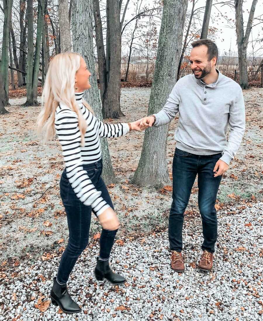 Candid photo of husband and wife holding hands in the woods 