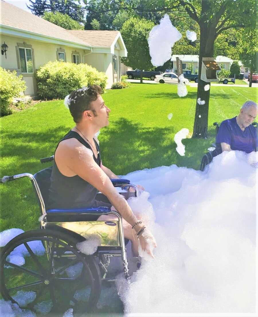 Man on a wheel chair playing on a bubble party 