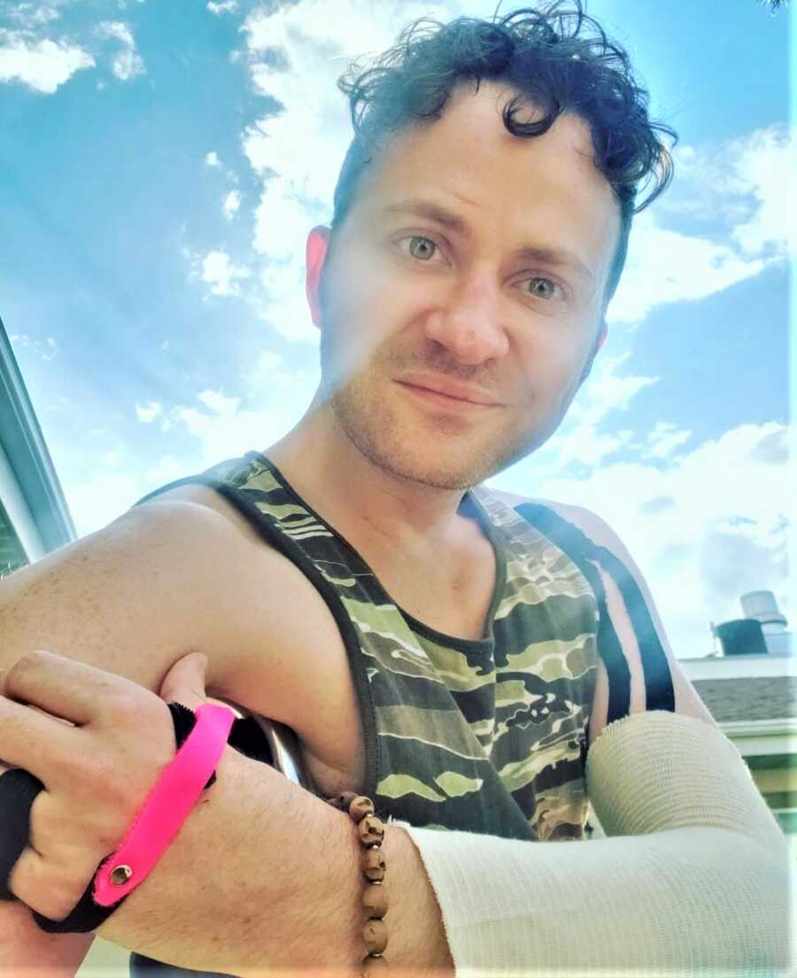 selfie of man smiling with a cast on his left arm 