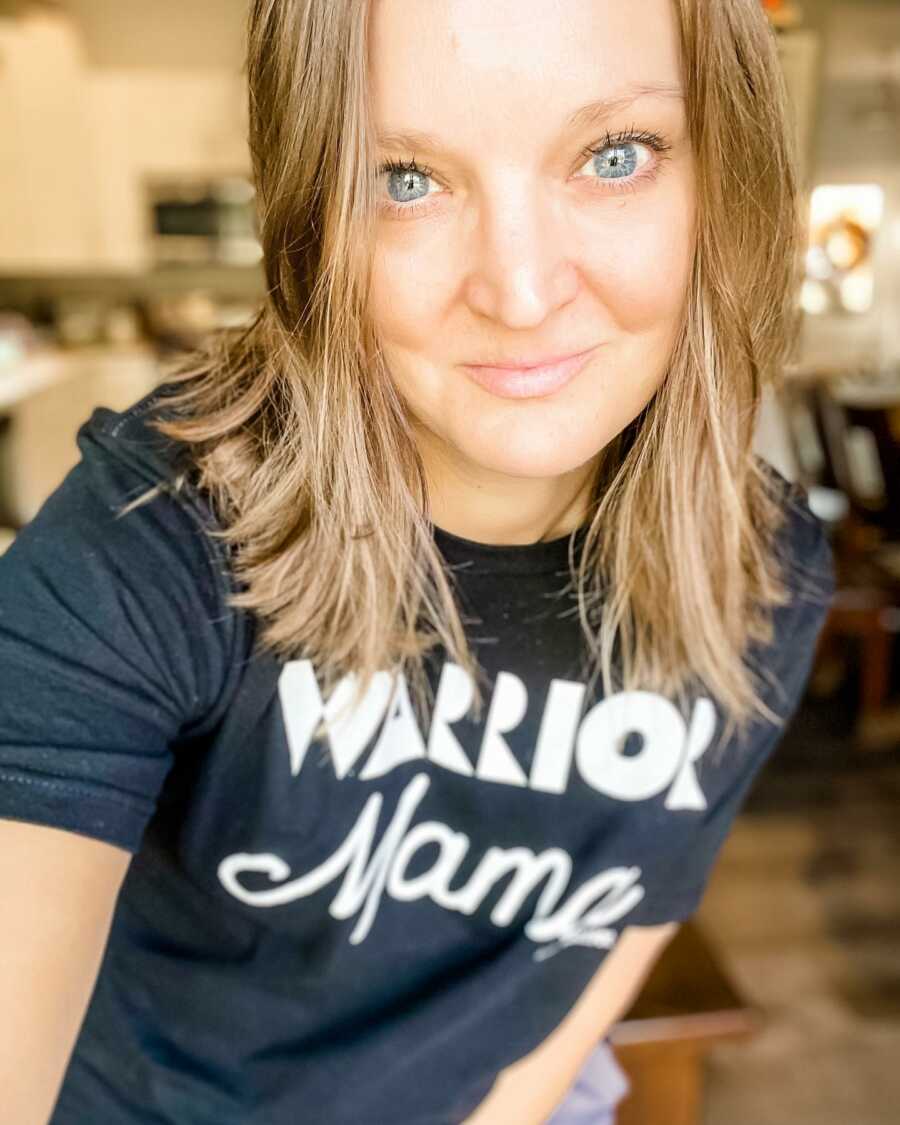 Special needs mom takes a serious selfie while wearing a black t-shirt that says "Warrior Mama" on it
