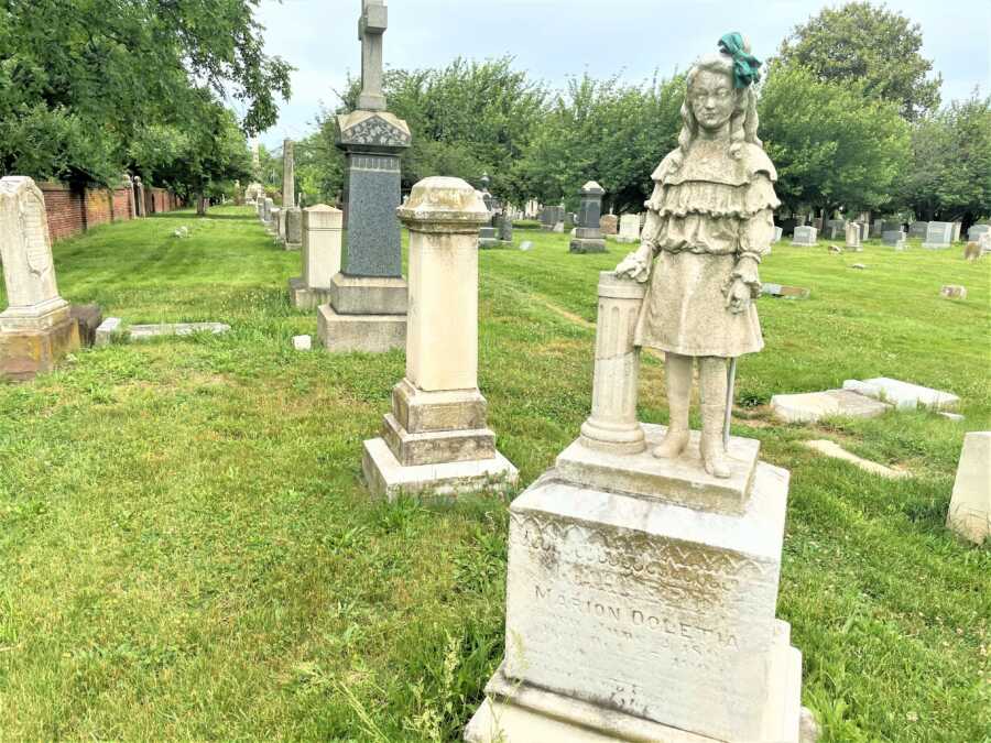 grave with a life-size statue of a young girl at the cemetery 