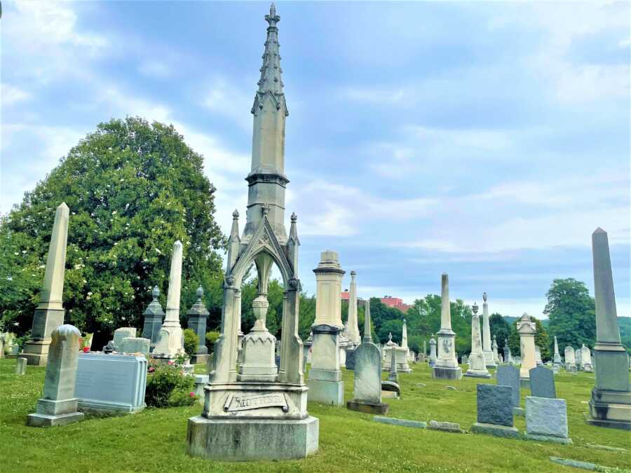 Long-shot of a cemetery with green grass and long statues 