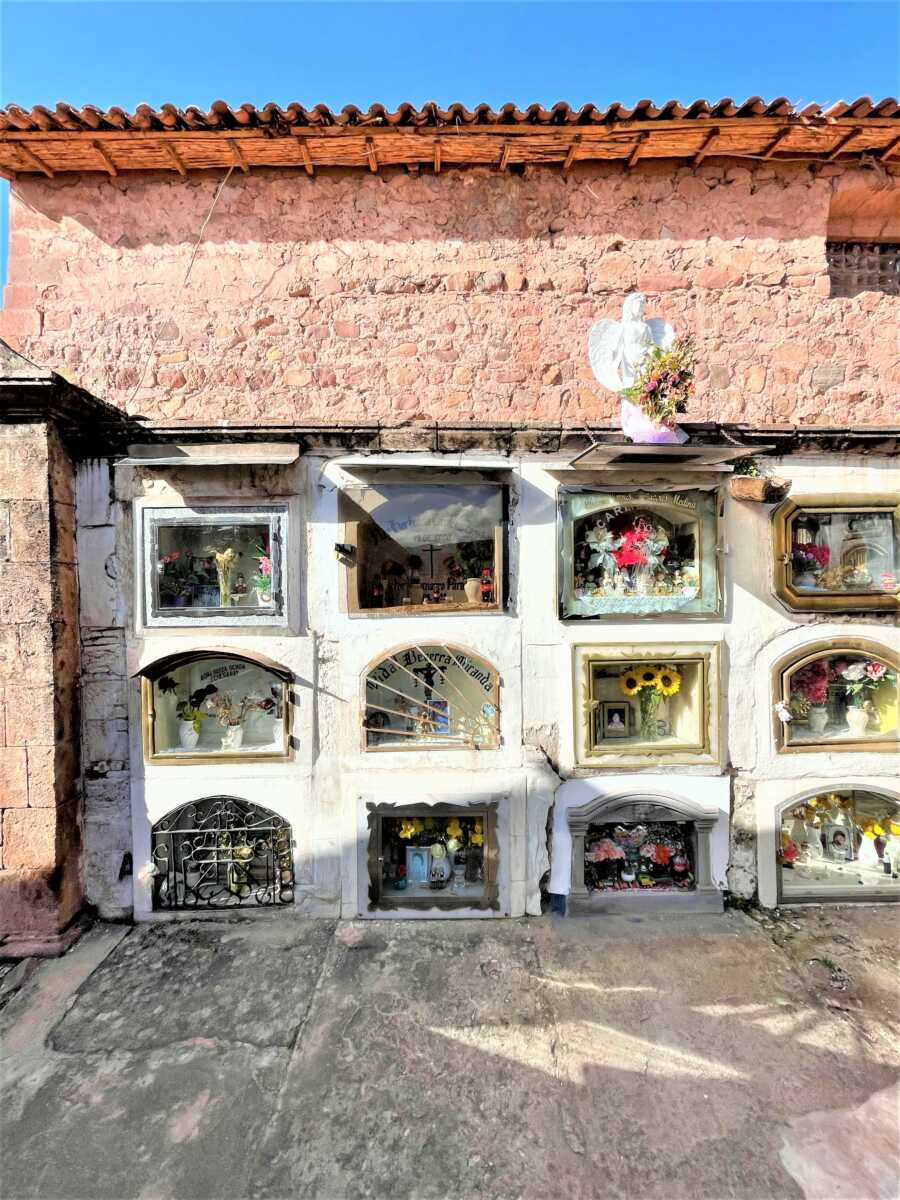 rustic cemetery with mud-structure and glass windows with flowers and memories of the deceased 