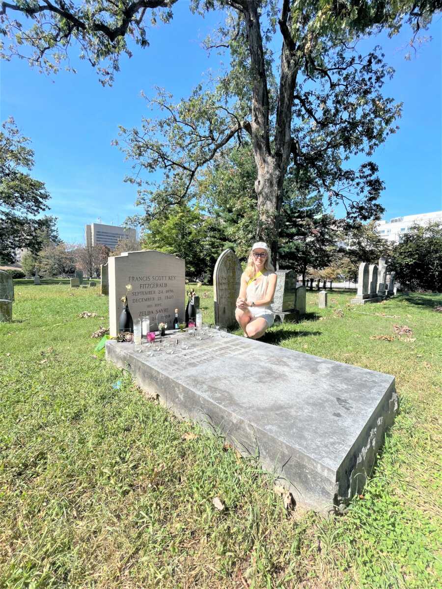woman at her grandma's gravestone with bottles and glasses laid down 
