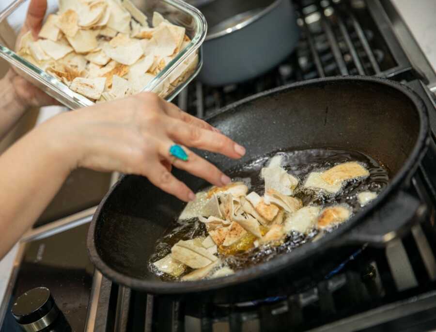 adding the fried bread in the pan