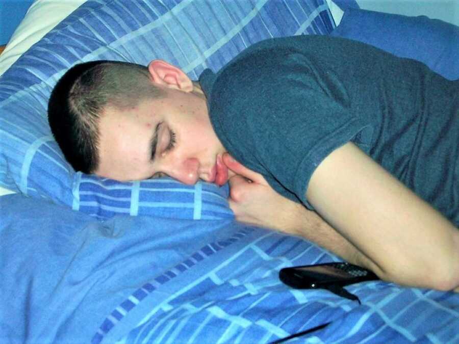 young man taking on a bed with blue sheets 