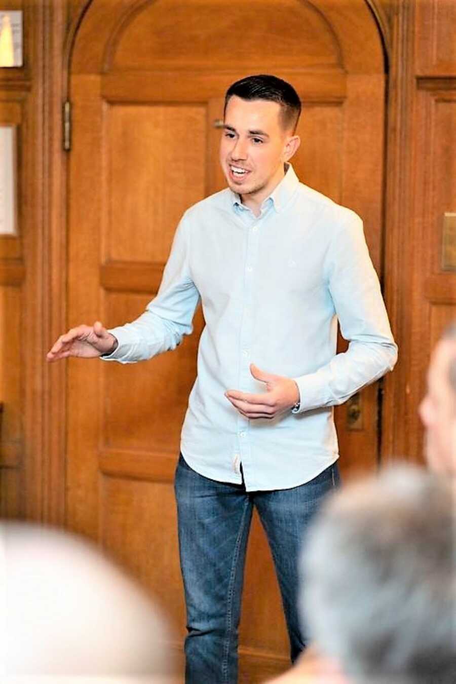 Young man giving an inspirational speech to a crowd 