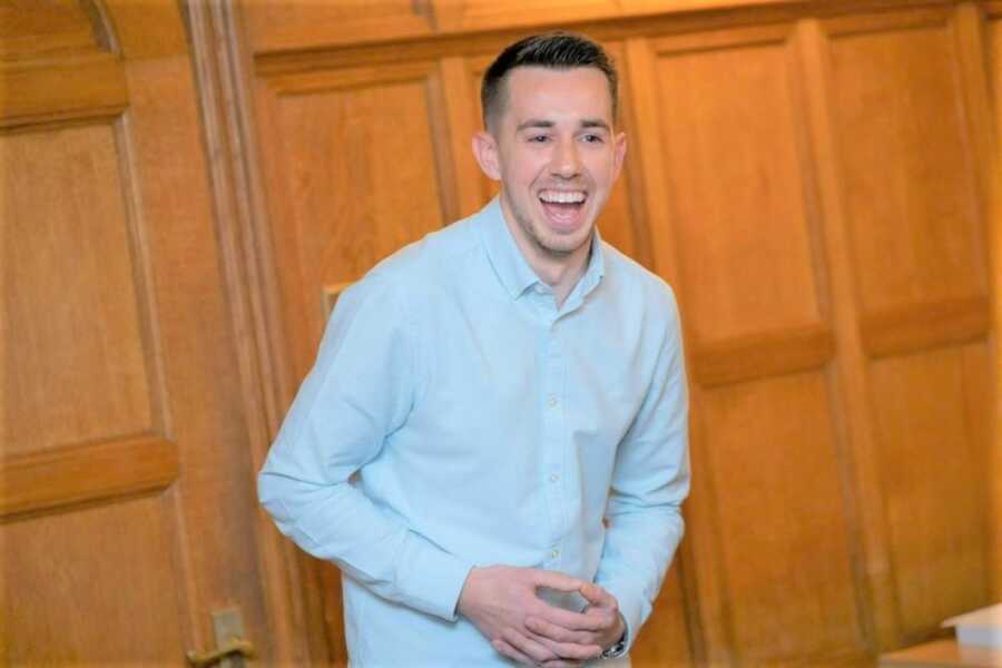 Young man laughing out loud while giving a speech