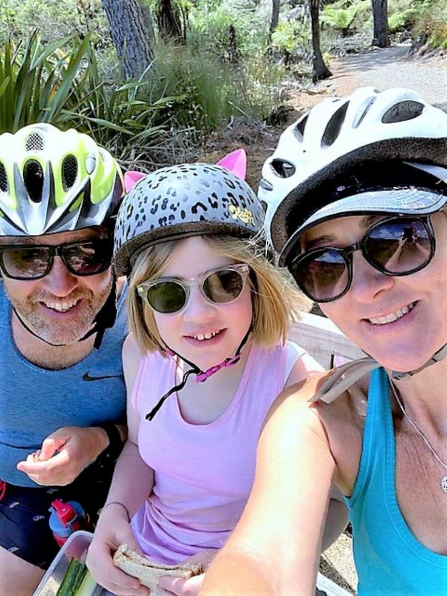 mom and dad biking with their young daughter 