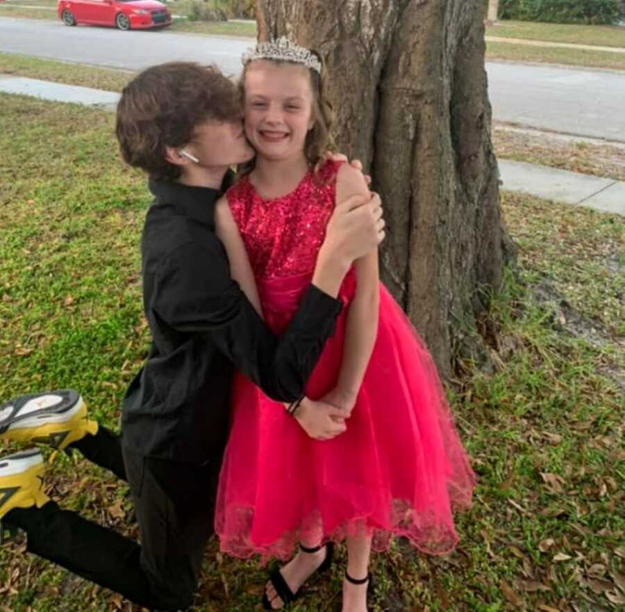 Big brother kisses his little sister on the cheek before going to a dance together