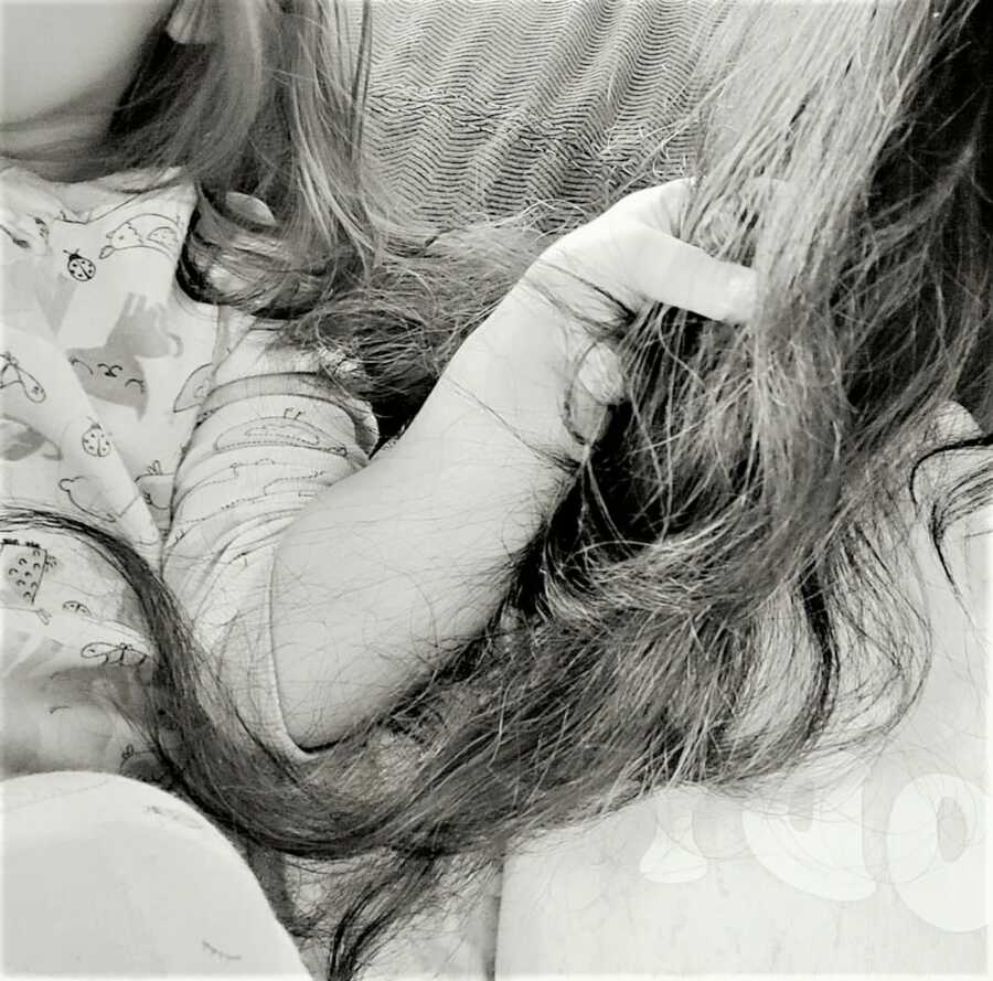 close-up of toddler daughter grabbing on to her mother's hair