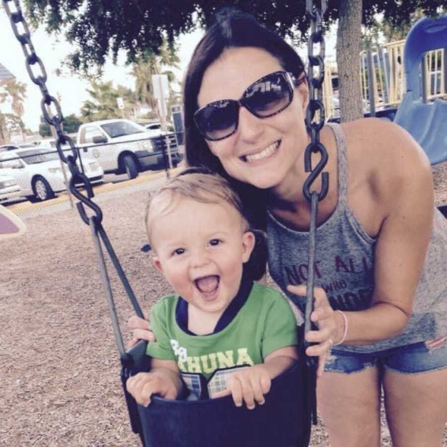 mom pushing son in a swing