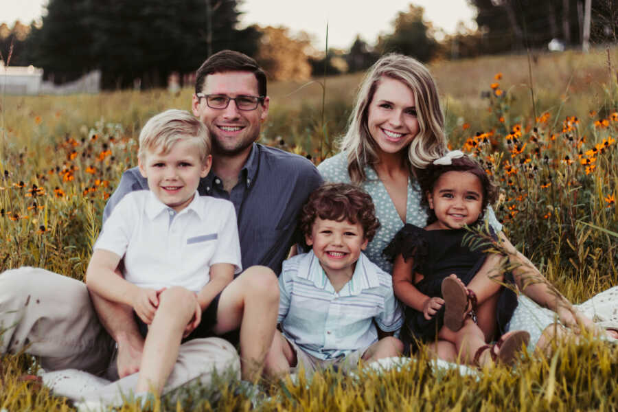 outdoor family portrait of mom and dad sitting on grass with their 3 kids 