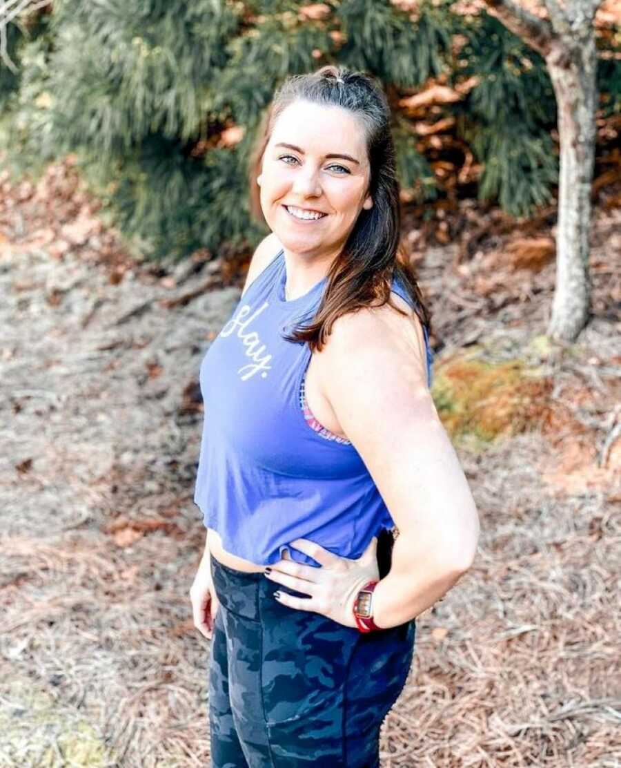 young woman standing outdoors wearing a crop top and leggings 