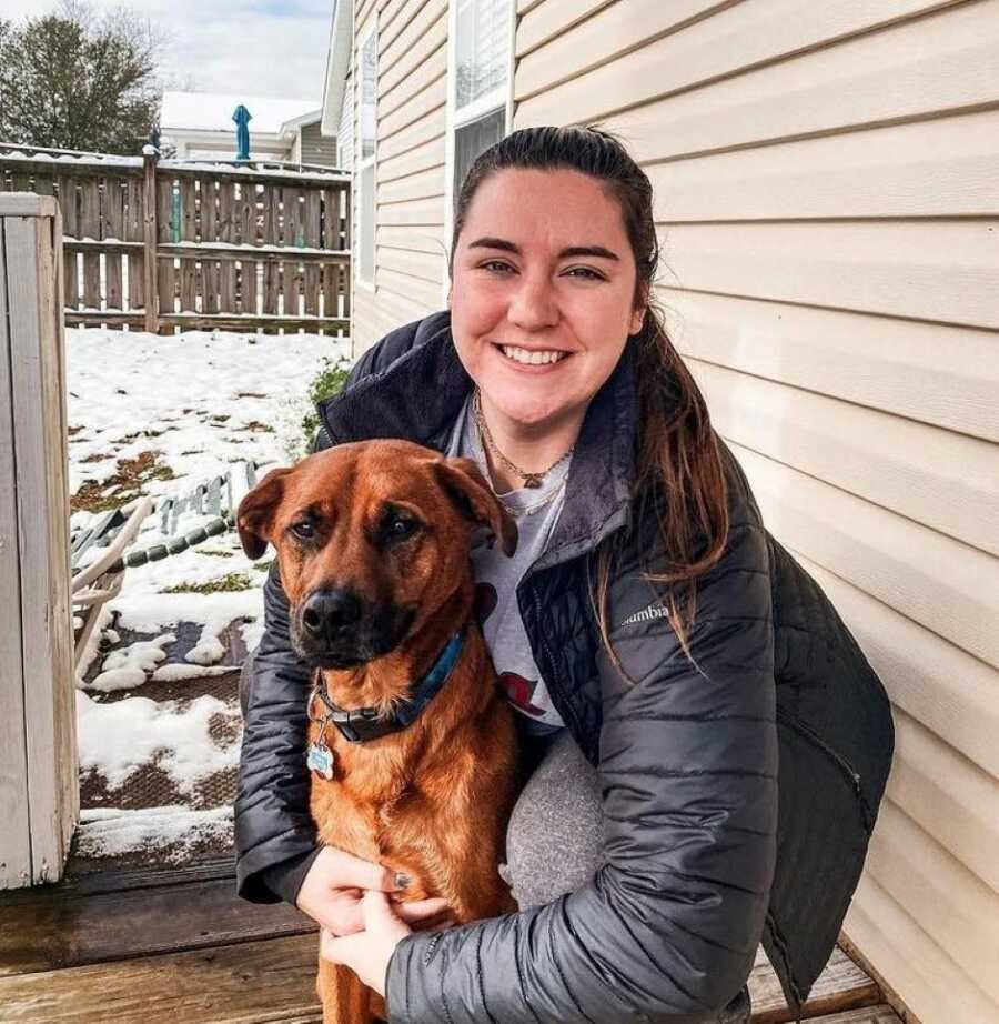 young woman and her dog sitting in a porch during on a winter day 