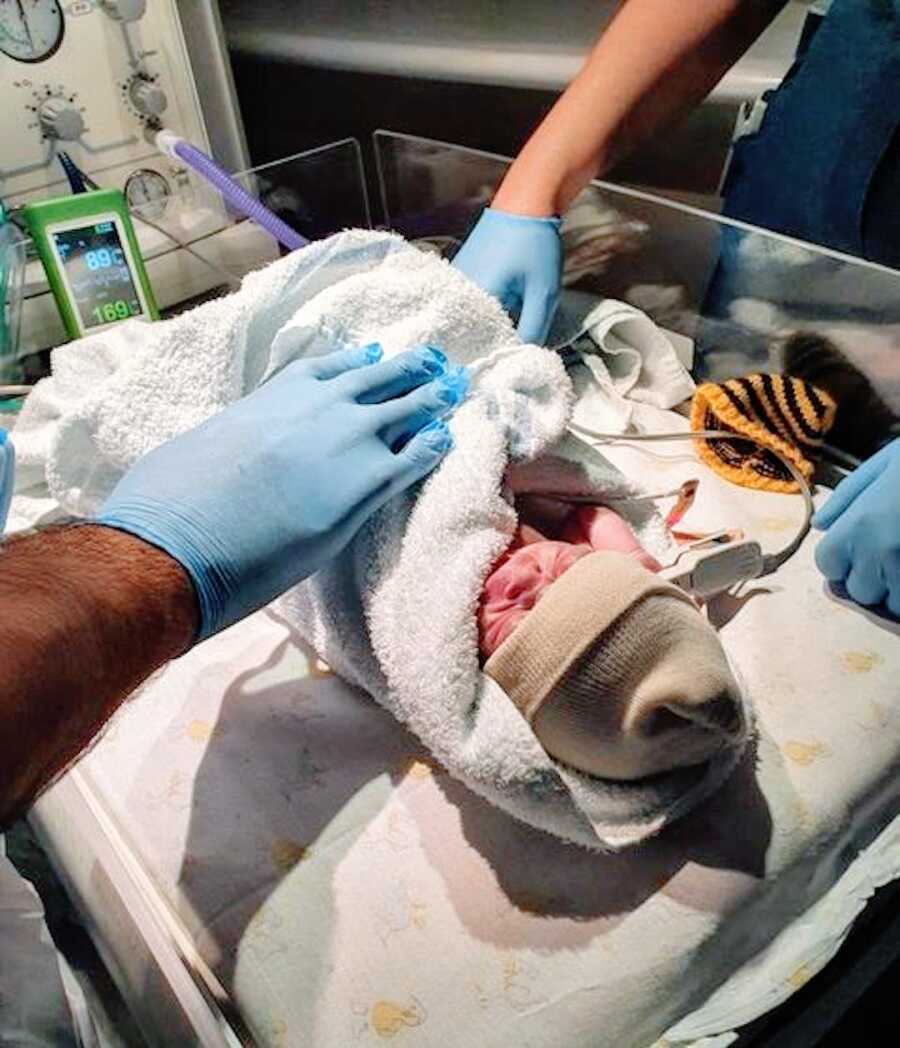 doctors checking infant right after birth