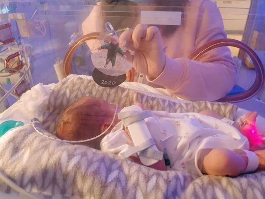 parents show baby in NICU a picture of her older sister