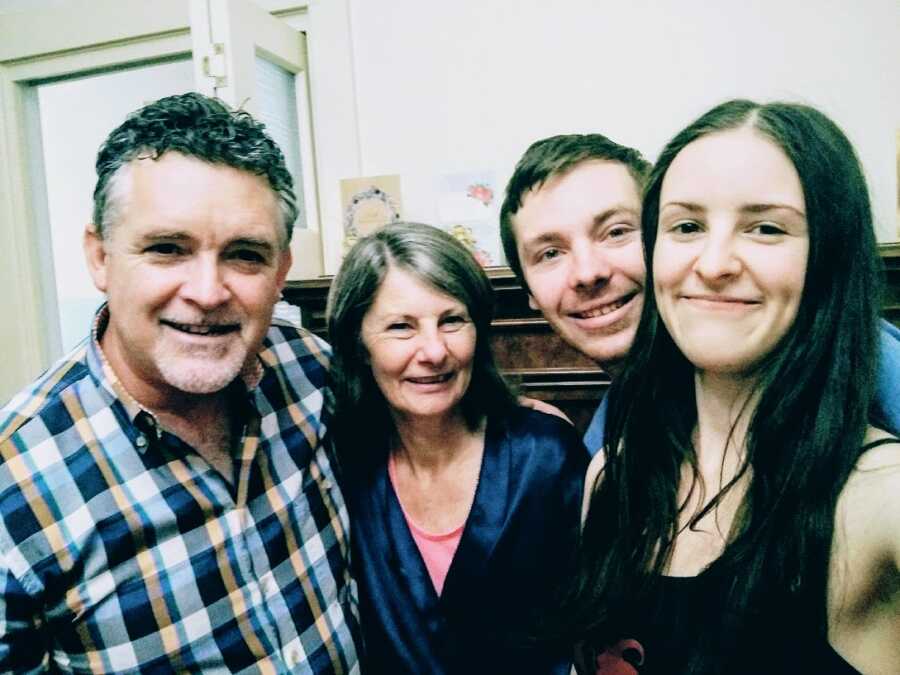 A visually impaired woman stands with three members of her family