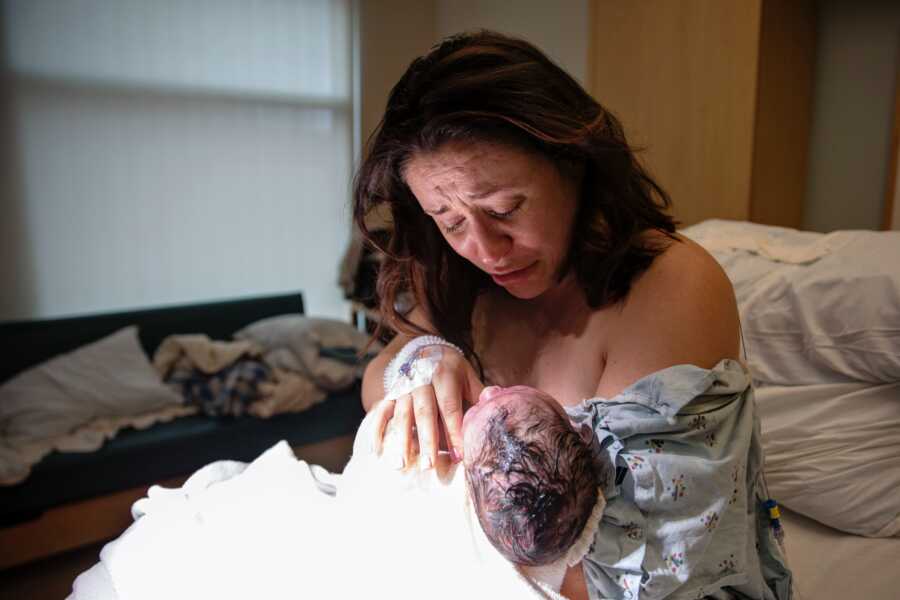 A mom holds her newborn baby in her arms