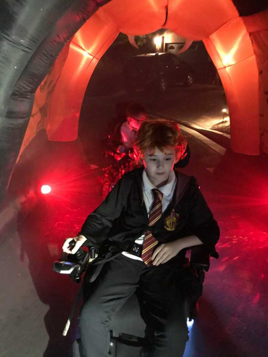 young boys in power wheelchairs go through inflatable Halloween tunnel