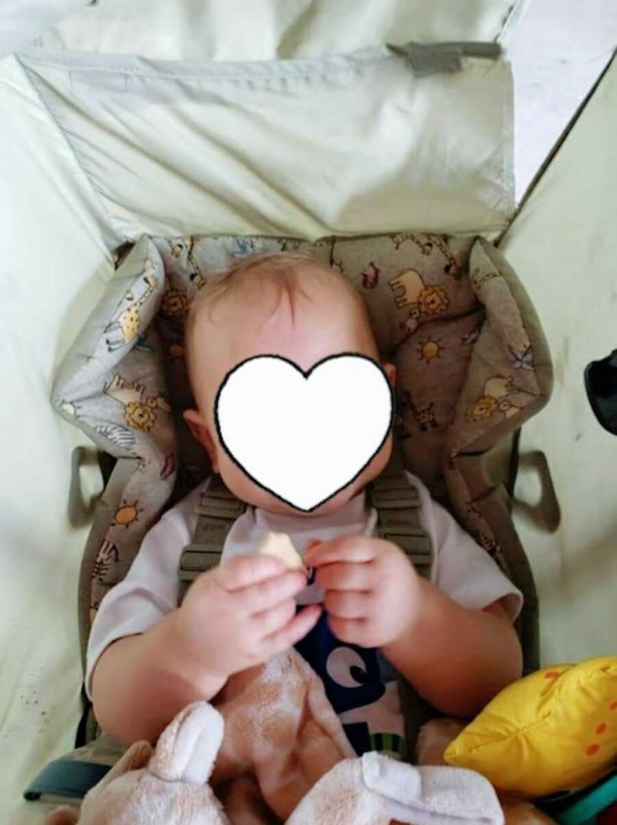 infant in their car seat holding food