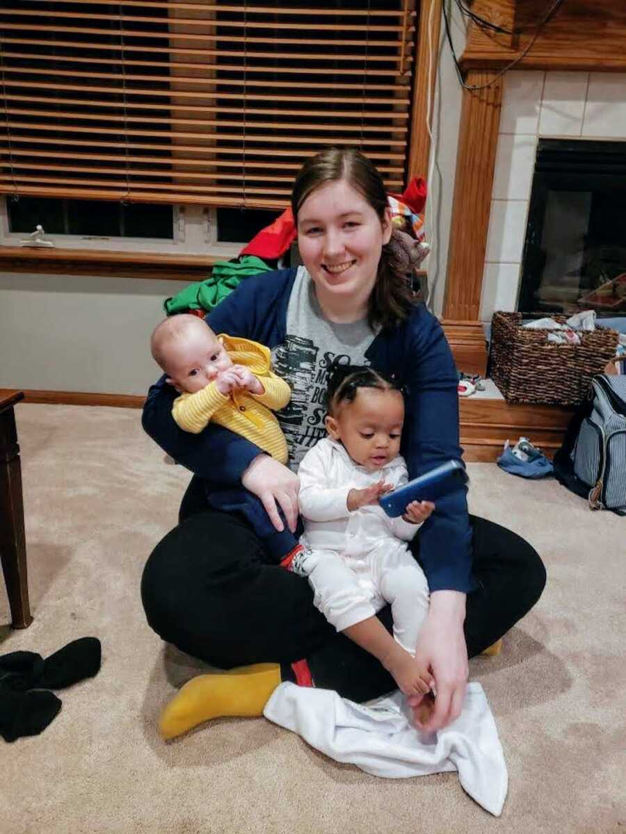 woman who helps struggling mothers holds two of the kids she cares for