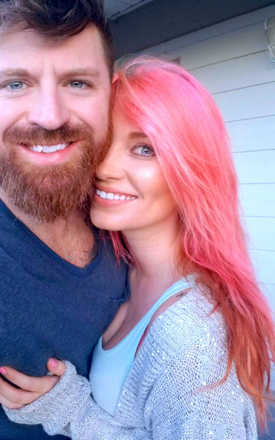 husband and wife take a selfie together, both are smiling