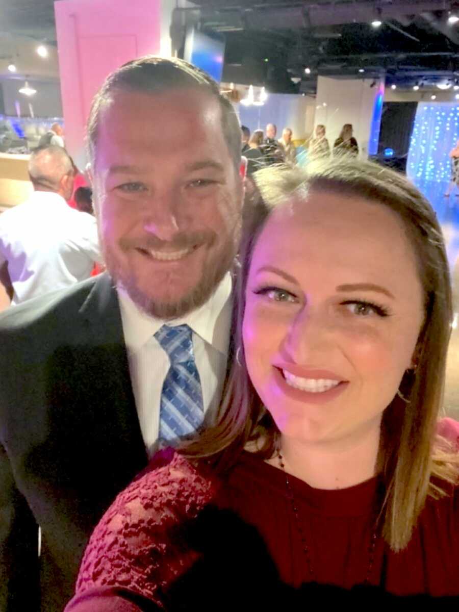 husband and wife take a selfie together smiling, wearing fancy attire