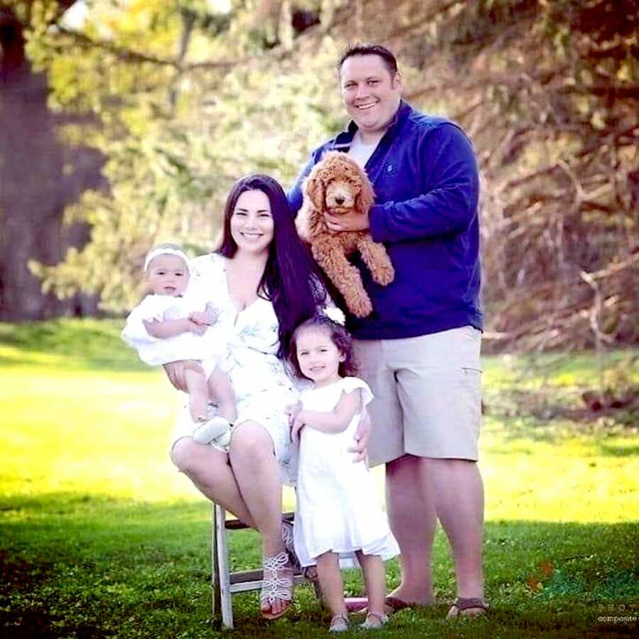 Husband and wife gather together with their two children and family dog