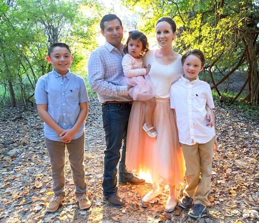 Parents stand with their three children