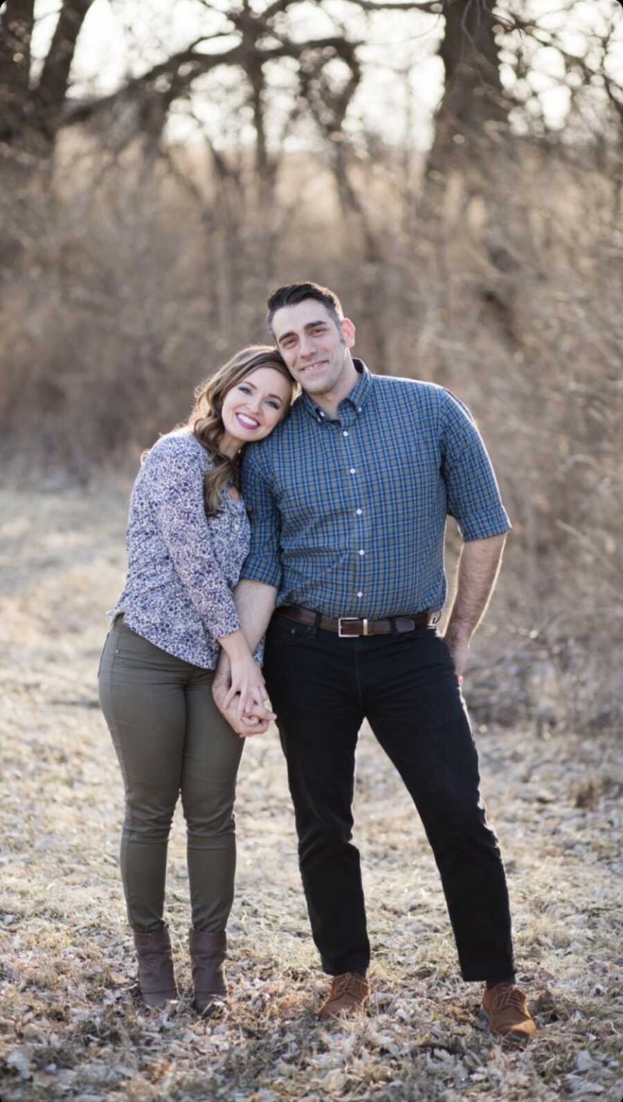 couple stands together holding hands