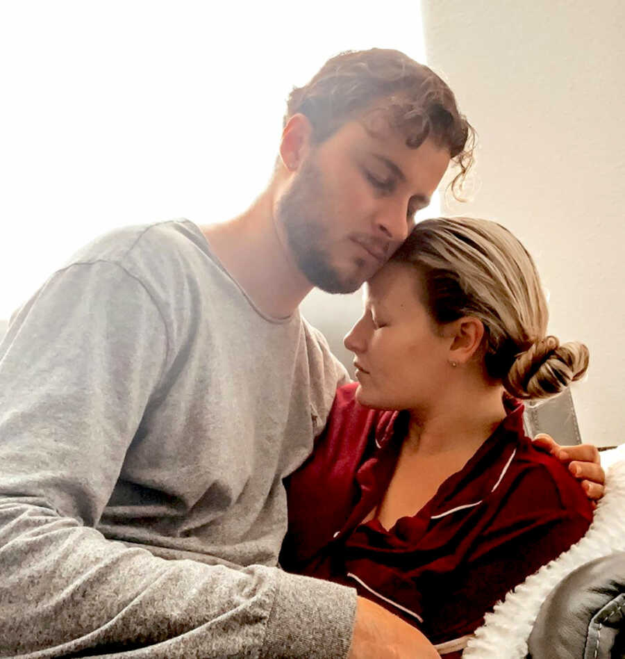 couple sits together heads together