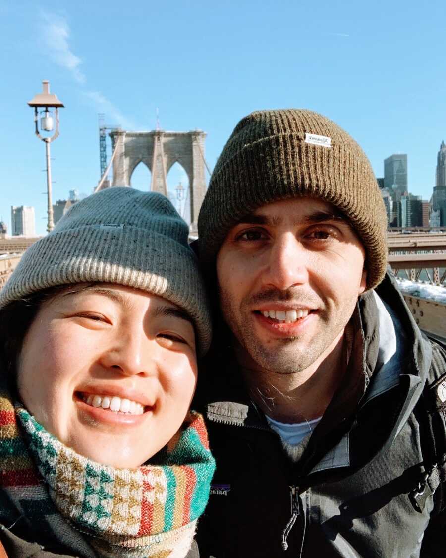 A woman and her husband stand on a bridge in New York City