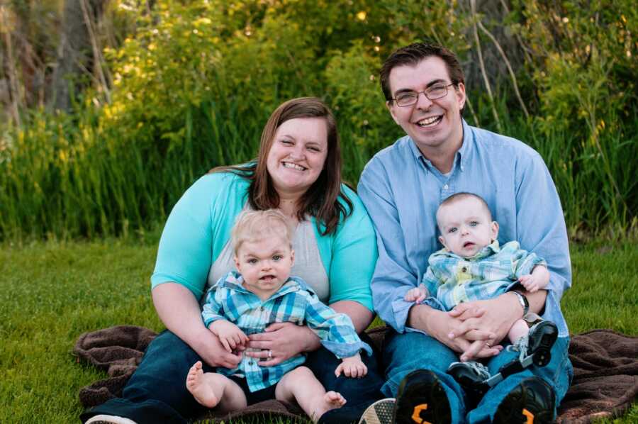 parents sitting outside and holding their two autistic sons