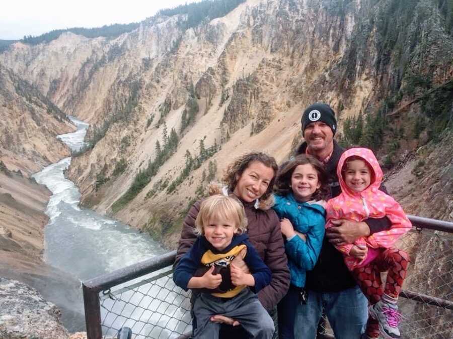 A family with three kids hiking near a river gorge