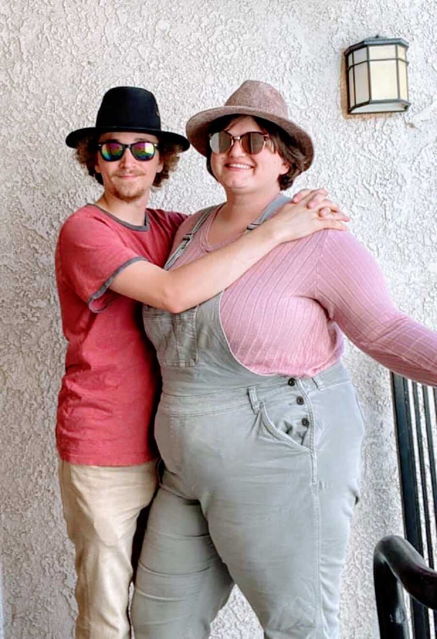 A woman and her partner wearing sunglasses on a balcony