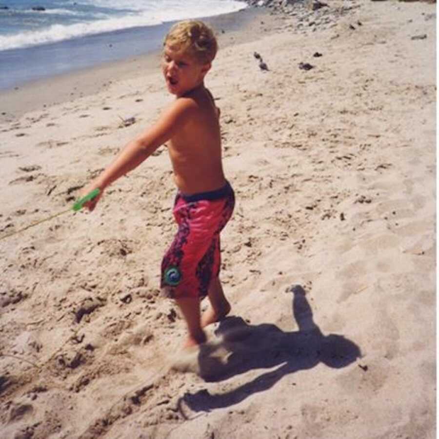 little brother on the beach playing