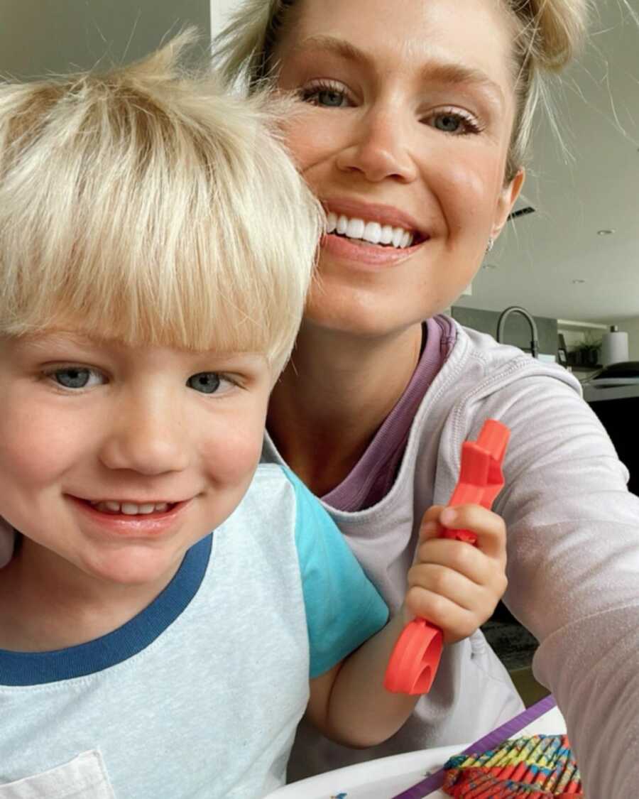 Young mom and toddler son take cute selfie together.