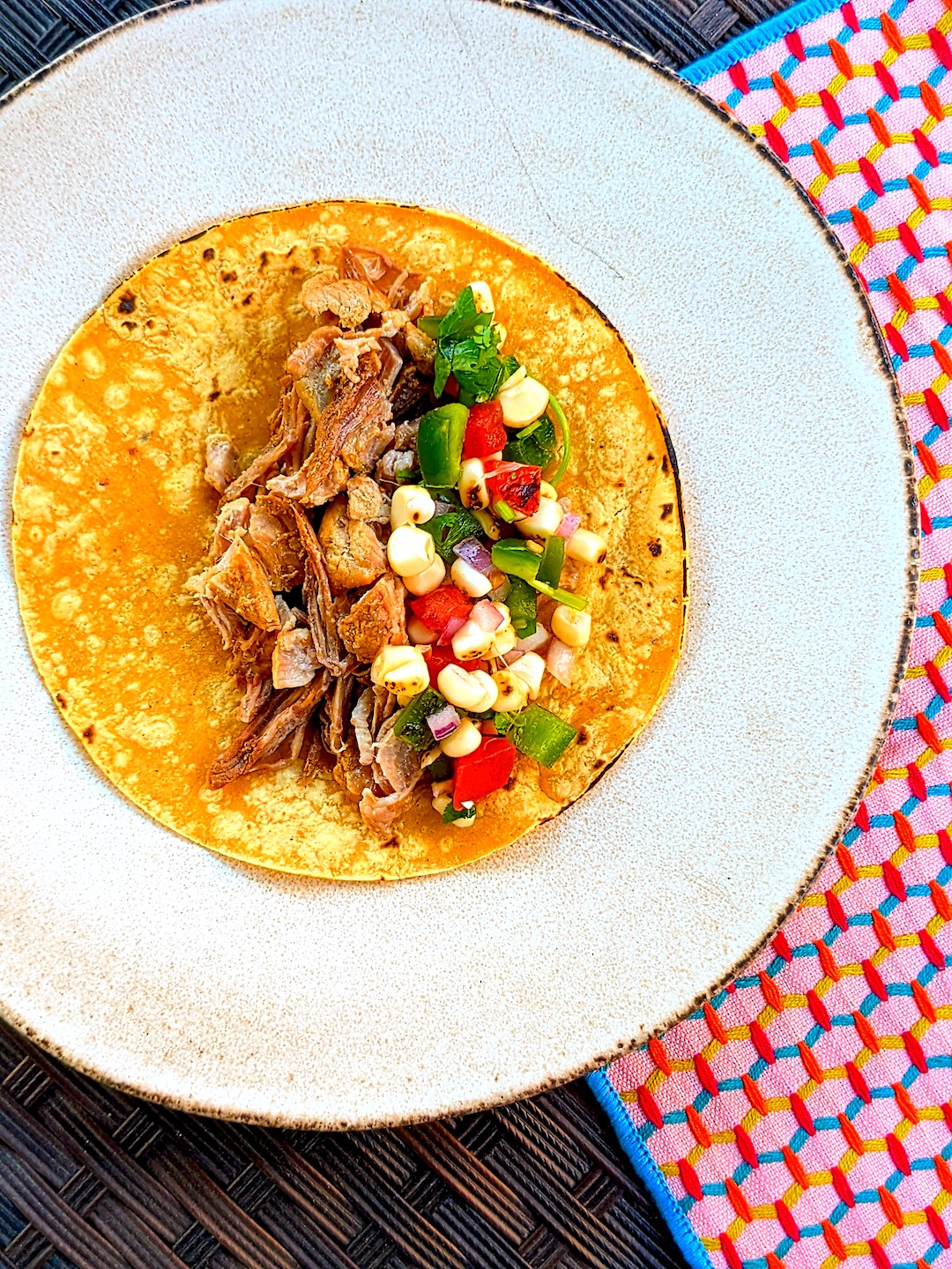 finished plate with pork carnitas on a tortilla with pico de gallo